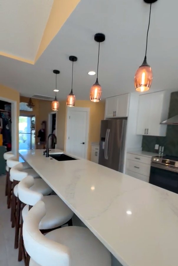 Kitchen island with waterfall quartz countertop and pendant lighting in Panama City Beach