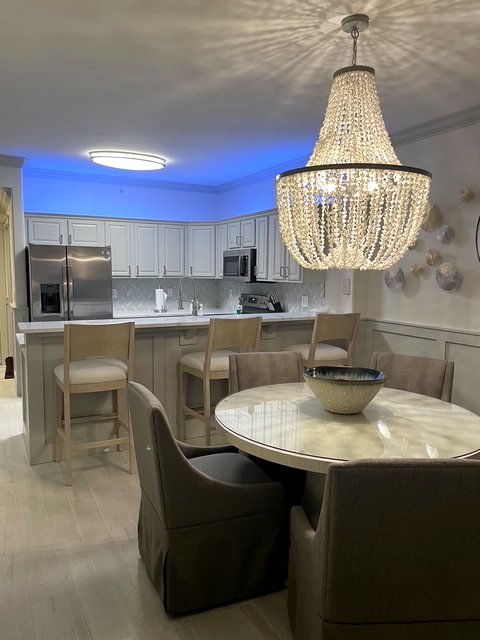 Kitchen and dining area with a crystal chandelier and blue LED accent lighting in Panama City Beach